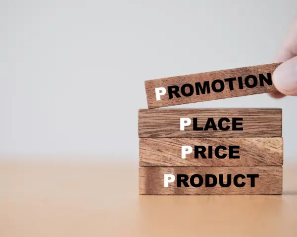 Drewniane klocki z napisami: Product, Price, Place, Promotion.