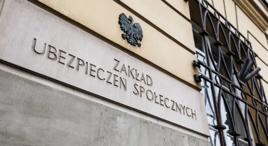 Tablica z napisem "Zakład Ubezpieczeń Społecznych" i godłem Polski.