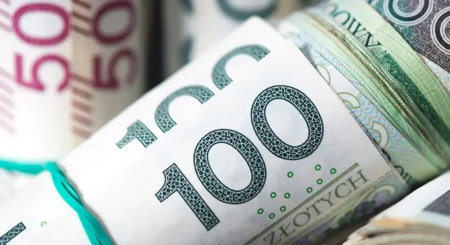 Zwijane banknoty 100 zł i 50 zł związane gumką.